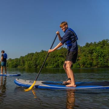 Two students paddleboard on the Chippewa River.