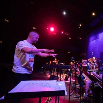 A Blugold alum helps Blugold band members perform during a special performance at the Pablo Center.