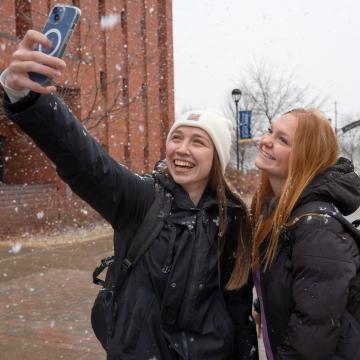 Students take a selfie during the first snowfall of November 2025.