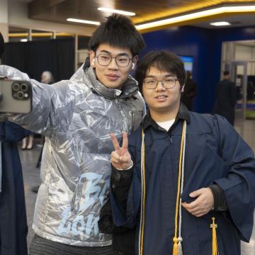 Students take a selfie on the day of Commencement. 