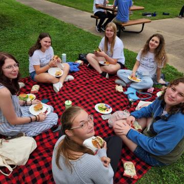 Honors Students sitting around a picnic blanket