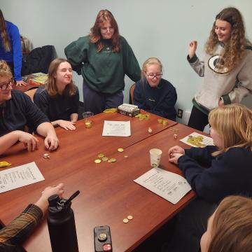Honors students gather around a table at game night