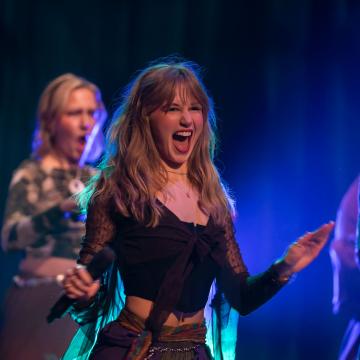 A student smiles while signing, clearly happy to be performing in the Cabaret!