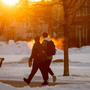 The rising sun shines on students walking to class on a cold January day.