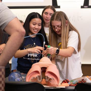 Pre-Professional Health Club students practice their technique on a manikin.
