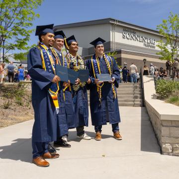 A group of students stand outside the Sonnentag Center following the Commencement ceremony.