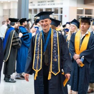 A student smiles to the camera following Commencement.