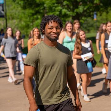 Students smile at the camera as they walk around campus during Orientation.