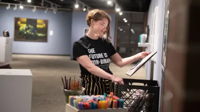 student setting up exhibit in Foster Gallery