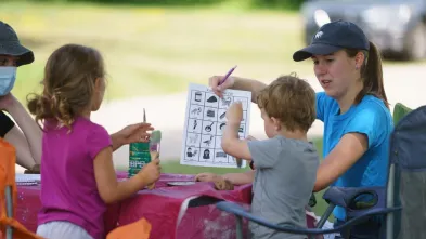 student working with community youth outdoors 