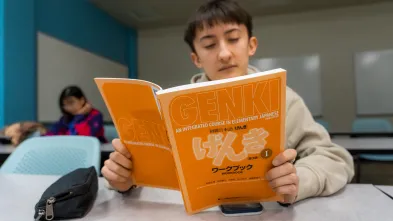 student holding textbook in Japanese language class