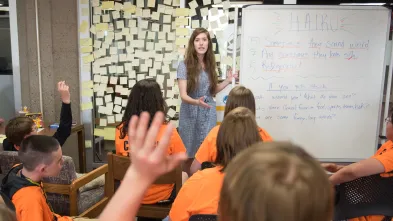 English student giving youth a writing lesson