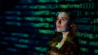 student in front of a screen of data 