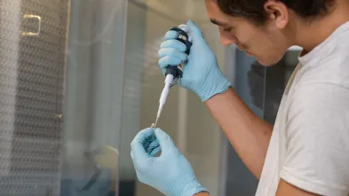 biomed lab male research student filling vials 