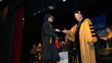 Chancellor Schmidt shaking graduate hand, Barron campus 