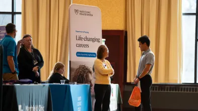 Student talks with a Mayo Clinic Health worker at the Health Career Fair