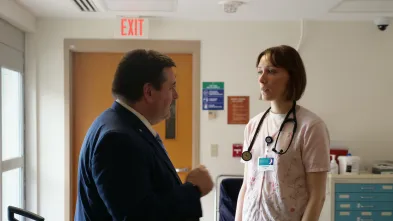 Public health student speaks with a doctor in a hospital hallway