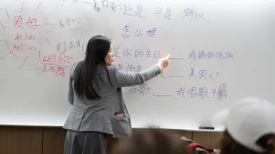 A professor writes Chinese characters on a whiteboard