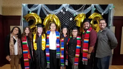 A group of graduates from the Latin American and Latinx Studies program pose in their colorful graduation attire.