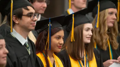 UWECBC students stand up during the Commencement ceremony.