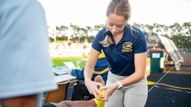 Student taping an ankle during a UWEC soccer game