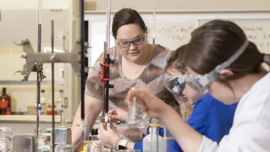 Students work on a chemistry experiment in a lab on campus.