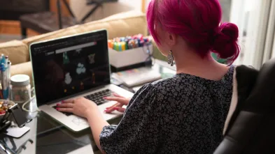 Student works at their computer in their dorm room.