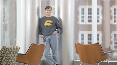 student standing in windows in Centennial Hall