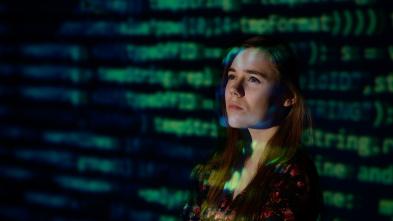 student in front of a screen of data 