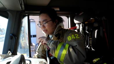 Student firefighter in gear in firetruck 