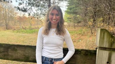 Jasmine Pearson stands in front of a fence.