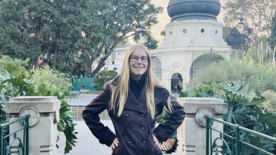 Student poses in front of a building.