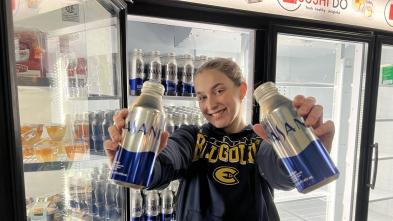 Student poses with new Dasani aluminum water cans