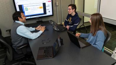 UW-Eau Claire faculty member and two students meeting