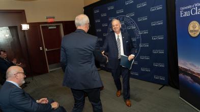 Chancellor Schmidt shaking hands with Dr. Michael Carney