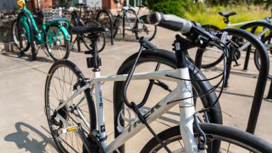 White bike in a campus bike rack locked up