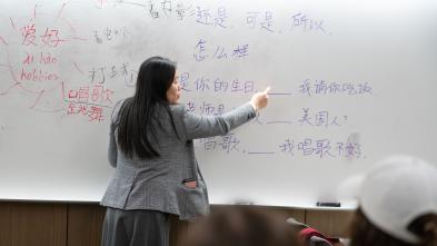 A professor writes Chinese characters on a whiteboard