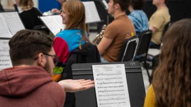 Students look at sheet music on a music stand
