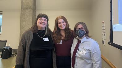 UWEC students Lee Rutzinski and Bree Muske and Writing Center assistant director Aubrie Warner grouped and smiling after a presentation 