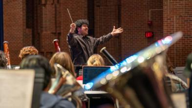 A conductor enthusiastically guides a musical performance