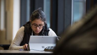 UW-Eau Claire – Barron County student studies in the commons area.