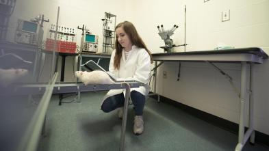 female student in neuroscience lab with white rat