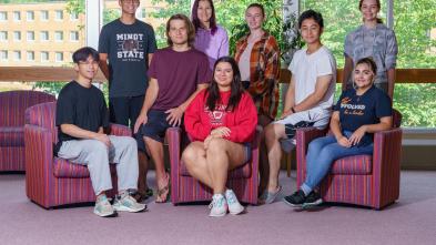 Group of students mixed genders, sitting and standing in library breezeway