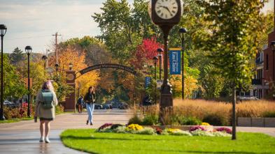 Students walk on Garfield Ave with UW Eau Claire arch in background.