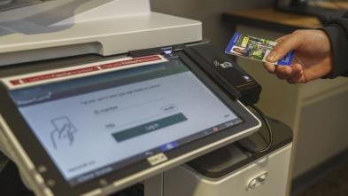 student using ID card to print