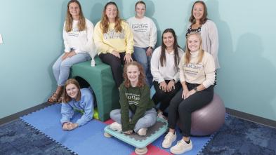 The research group of students and their professor pose in the sensory room they helped design.