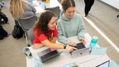 overhead view of two students at a desk station sharing an iPad