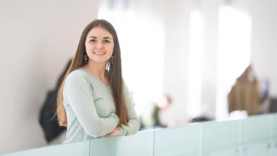Annie Fochs in second floor of Centennial Hall, leaning on glass half wall.