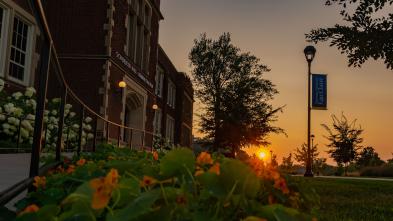 sunset over summer flower pot in front of Schofield Hall