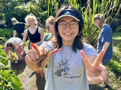 Yangguang Chen holding a shrimp up to the camera.